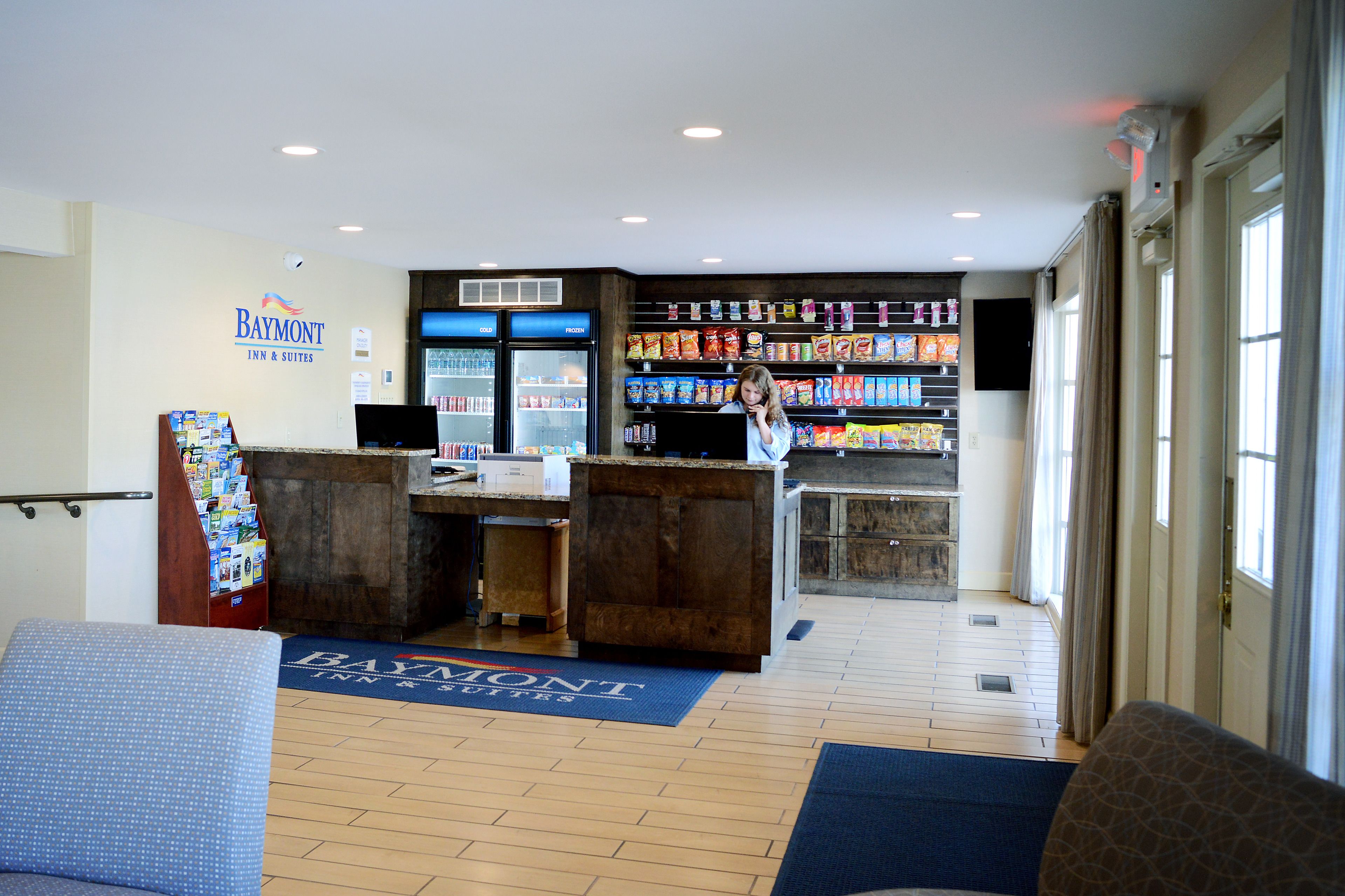 A hotel lobby with a reception desk, a snack bar, and a seating area.