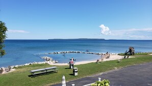 A beach with picnic tables, a playground, and a view of the ocean.