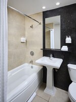 Een moderne badkamer met een badkuip, een wastafel en een toilet.