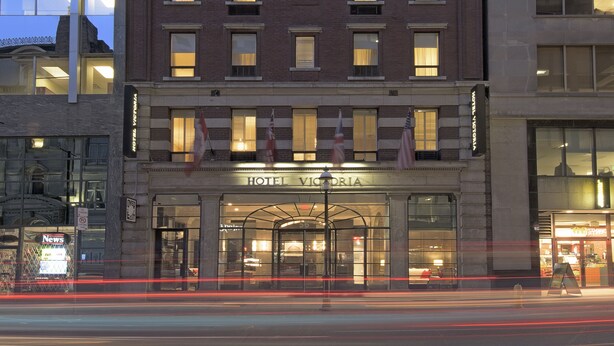 A multi-story hotel with a classic brick facade, large windows, and a prominent entrance with a sign reading "HOTEL VICTORIA". - Hotel Victoria (Toronto)