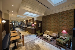 A spacious lounge area with a bar, seating arrangements, and a decorative floral wall.