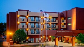 A hotel with a modern design, featuring multiple balconies and a well-lit entrance.