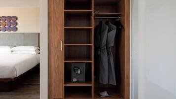 A bedroom with a wooden wardrobe, a bed, and a shoe rack.