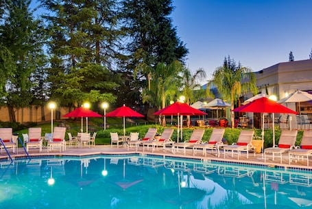 Una piscina al aire libre, sillones reclinables de piscina