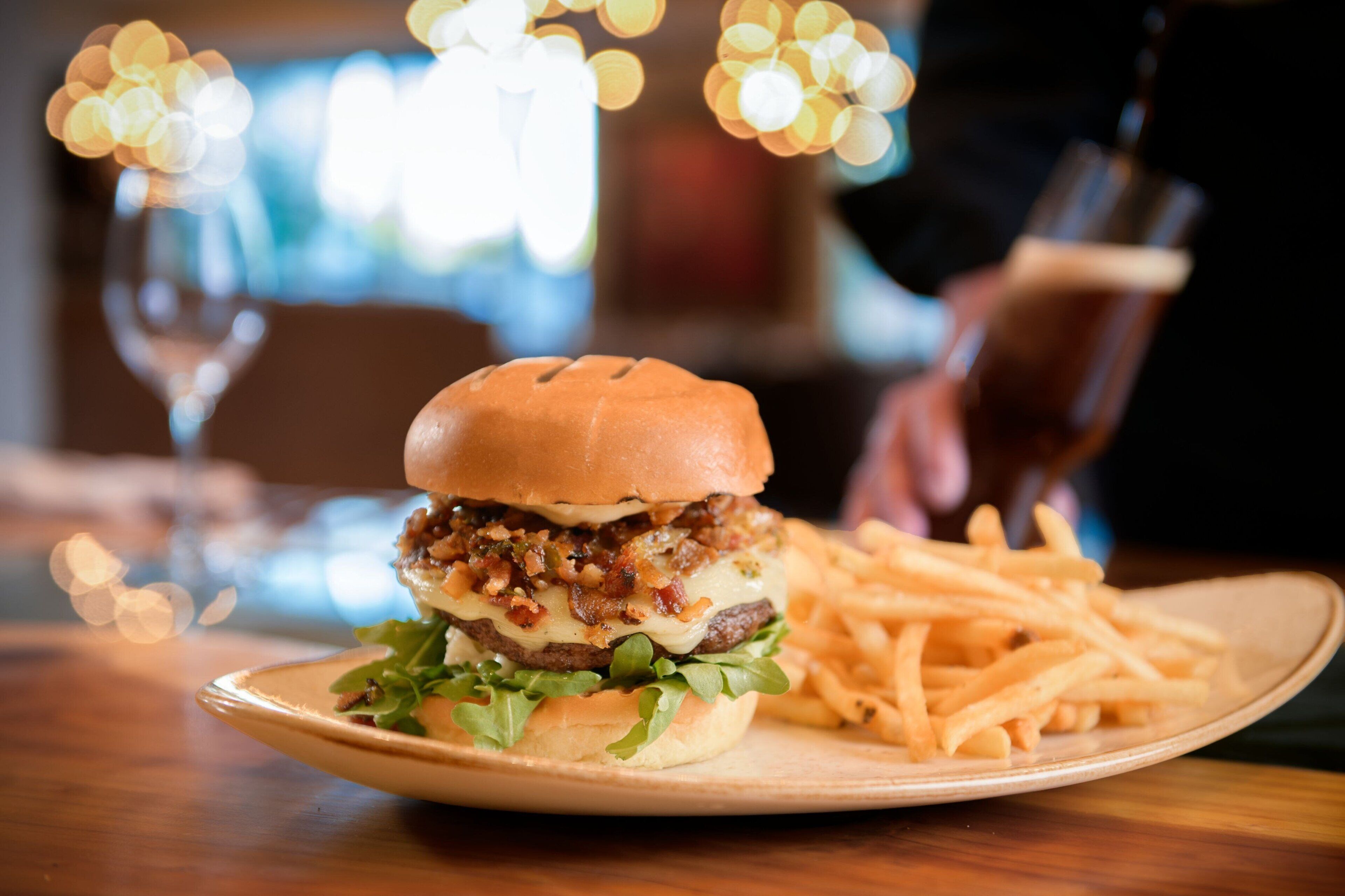 A plate with a burger and fries on a wooden table.