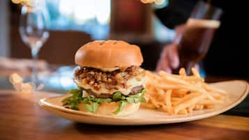 A plate with a burger and fries on a wooden table.