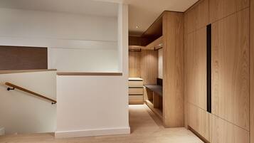 A modern interior with a wooden staircase, built-in shelving, and a minimalist design.