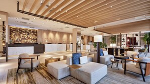 A modern hotel lobby with a reception desk, seating area, and a bar. - The Westin Grand Frankfurt (Frankfurt)