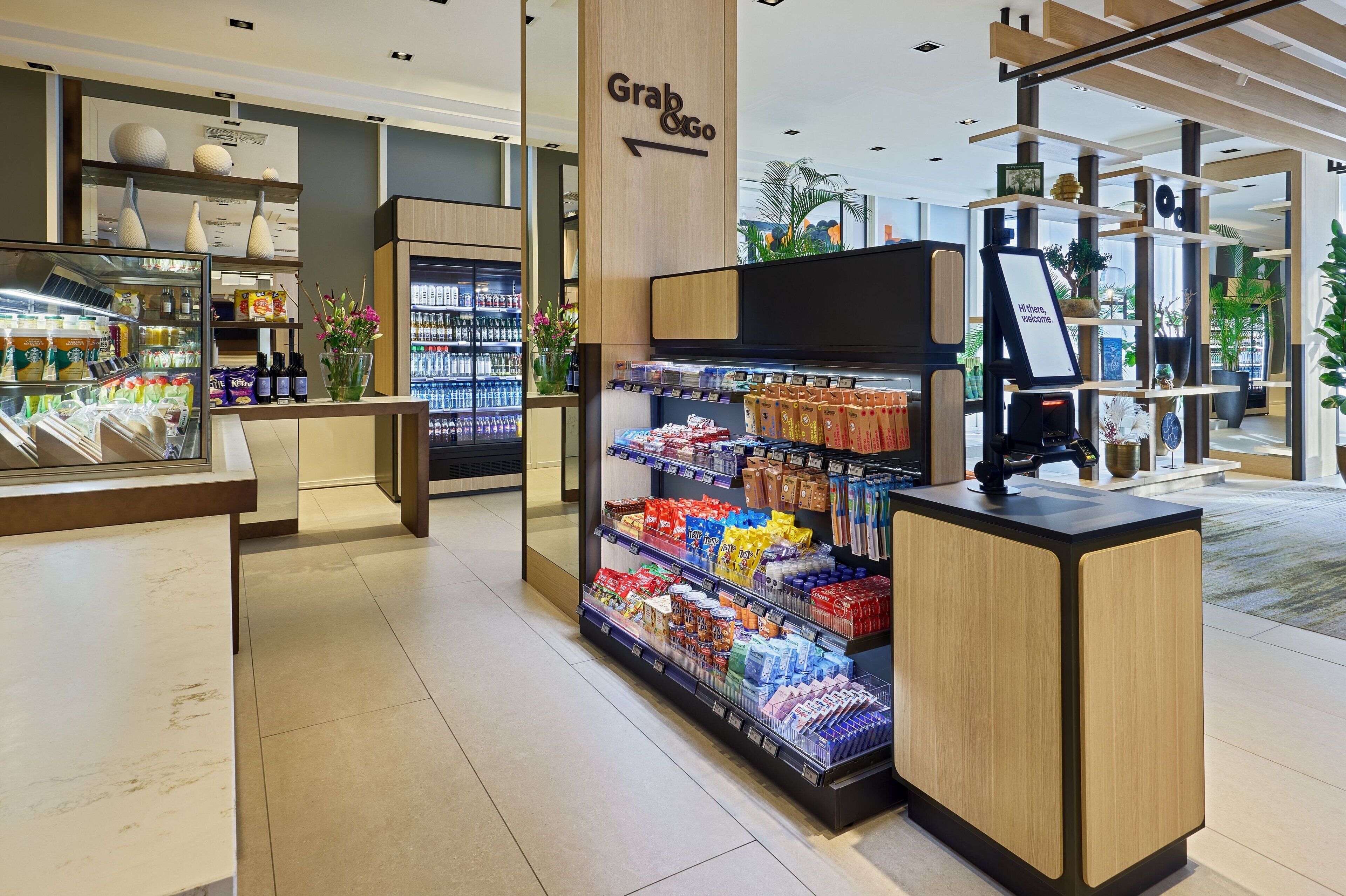 Interior de una tienda de comestibles con una sección 'Grab & Go', vitrinas refrigeradas y una variedad de productos envasados.