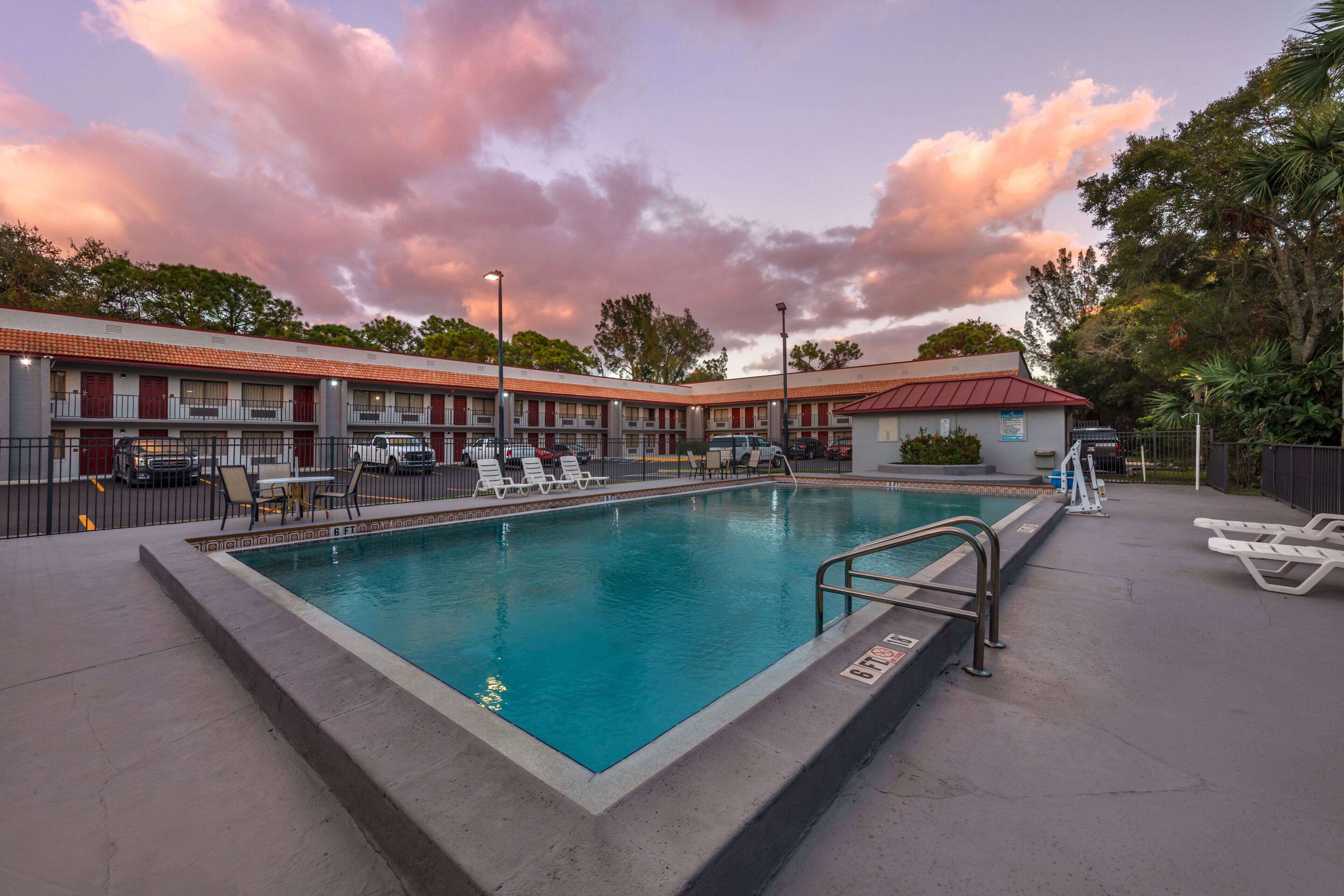 Una piscina al aire libre, sombrillas, sillones reclinables de piscina