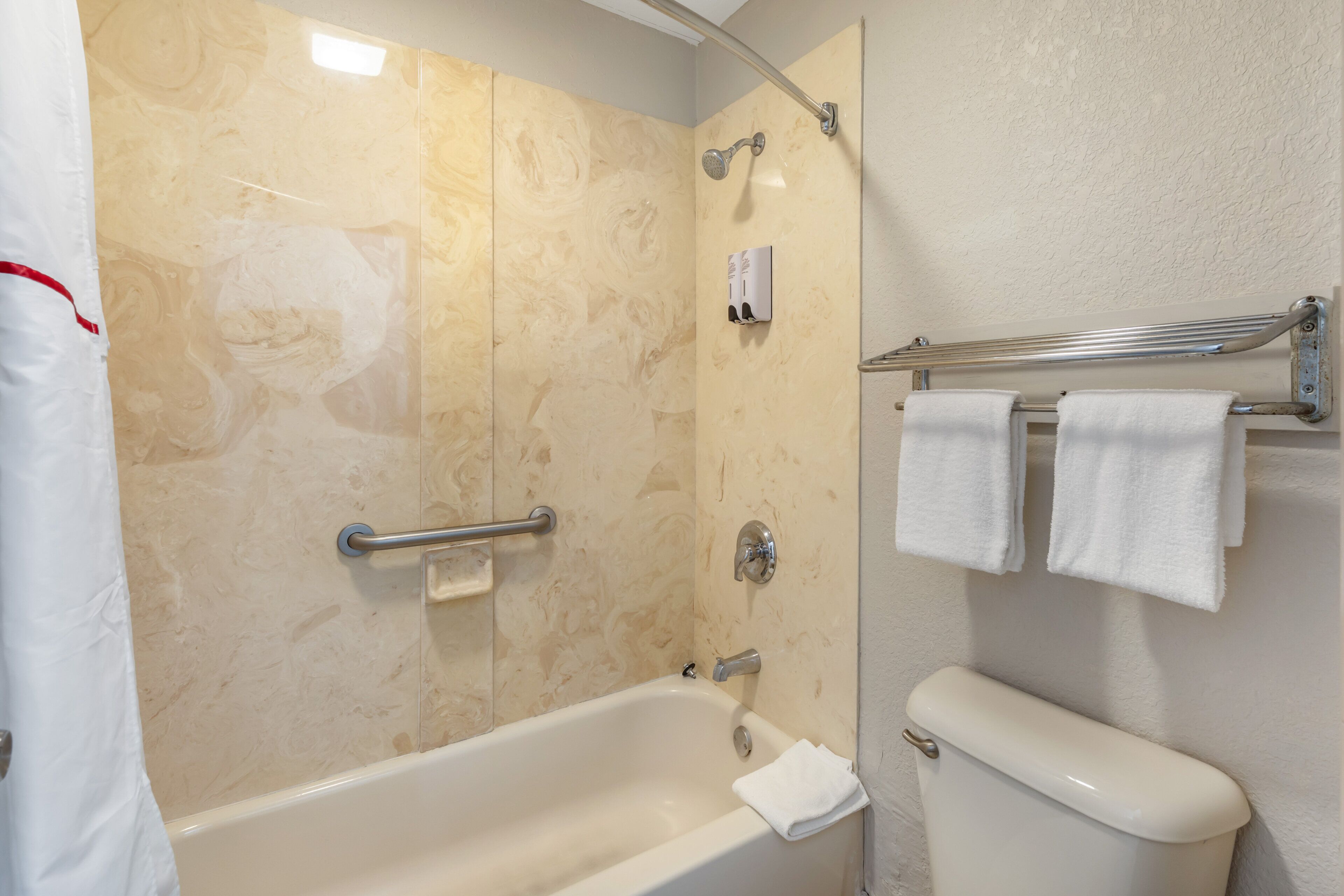 A bathroom with a bathtub, a shower, and a toilet.