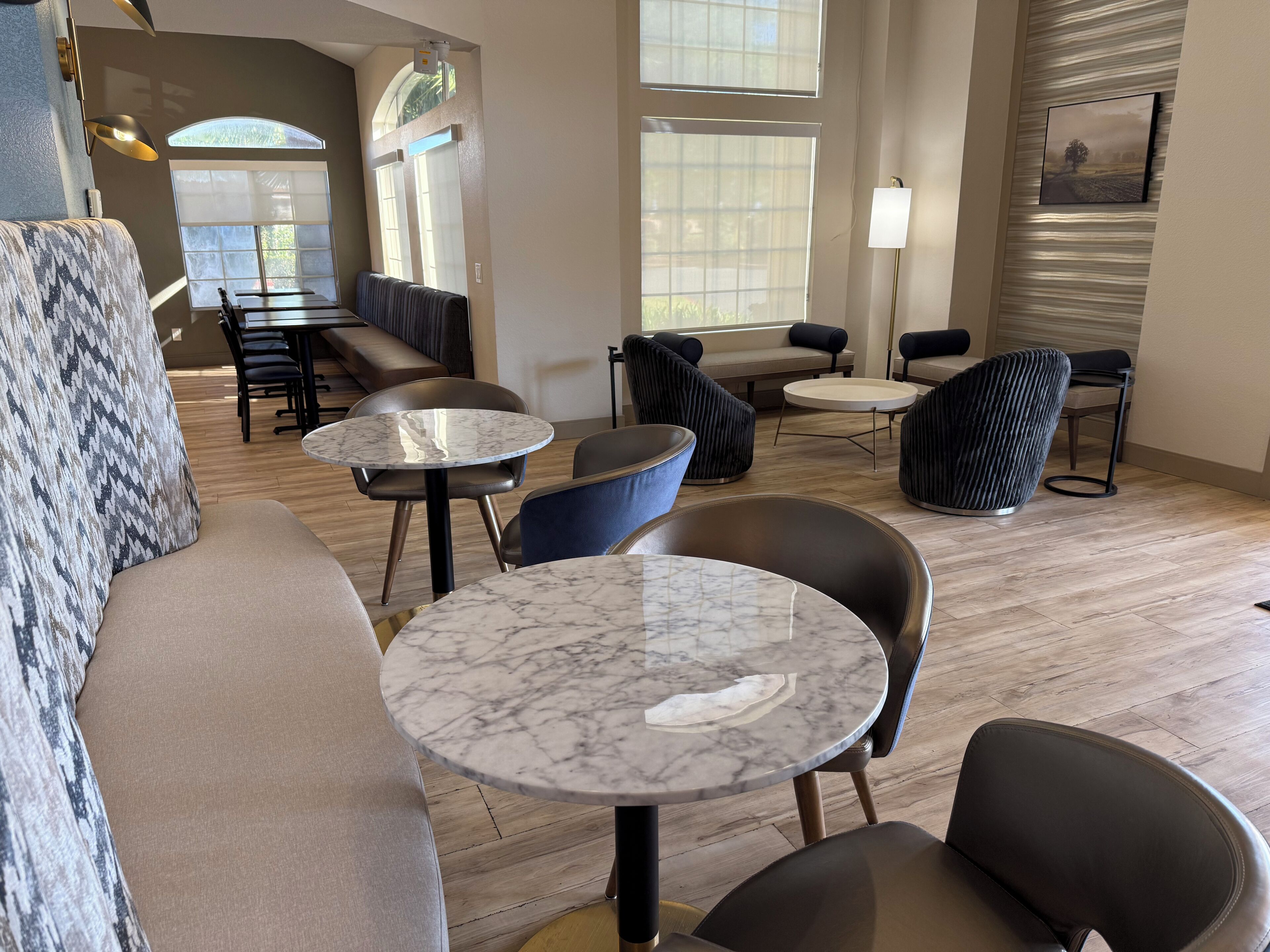 A modern lounge area with marble-topped tables, leather sofas, and a mix of seating arrangements.