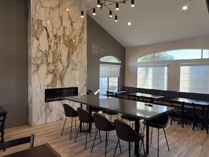 A modern interior with a marble wall, a long dining table, and multiple seating areas. - Best Western Palm Court Inn (Modesto)