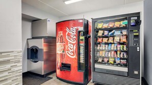 Un distributeur automatique arborant le logo Coca-Cola et un autre distributeur proposant des en-cas.