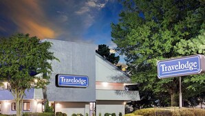 Un hôtel Travelodge au design moderne, doté d’une enseigne bien visible et d’un aménagement paysager soigné.