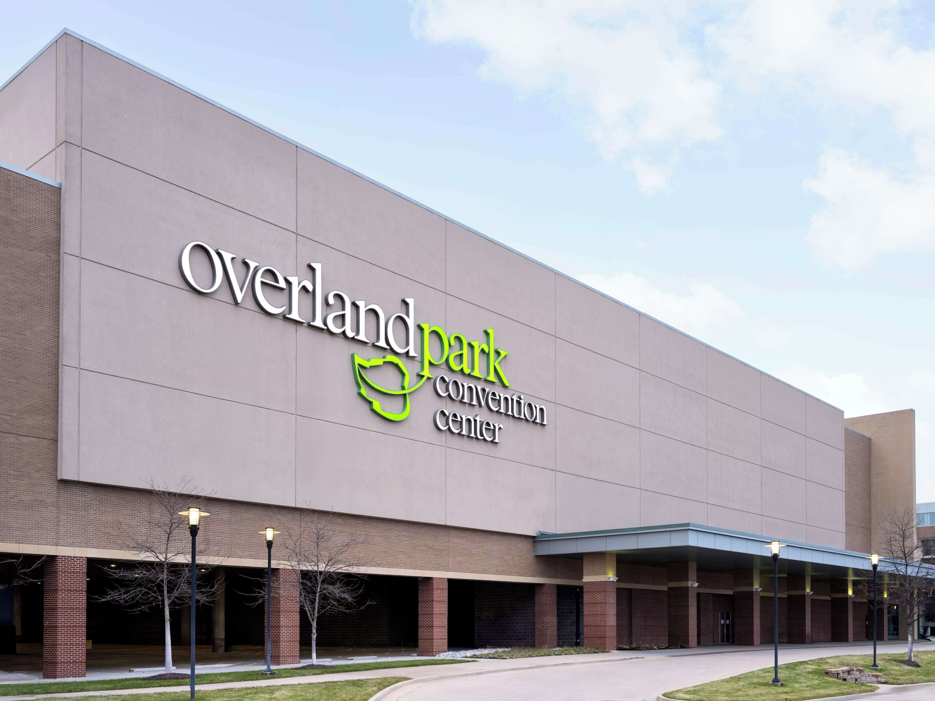 The exterior of the Overland Park Convention Center with a large sign, brick pillars, and a covered entrance area.