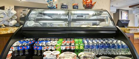 A food display case with various snacks and beverages, including Pepsi, Mountain Dew, and Aquafina water.