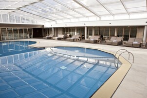 Una piscina techada, sillones reclinables de piscina