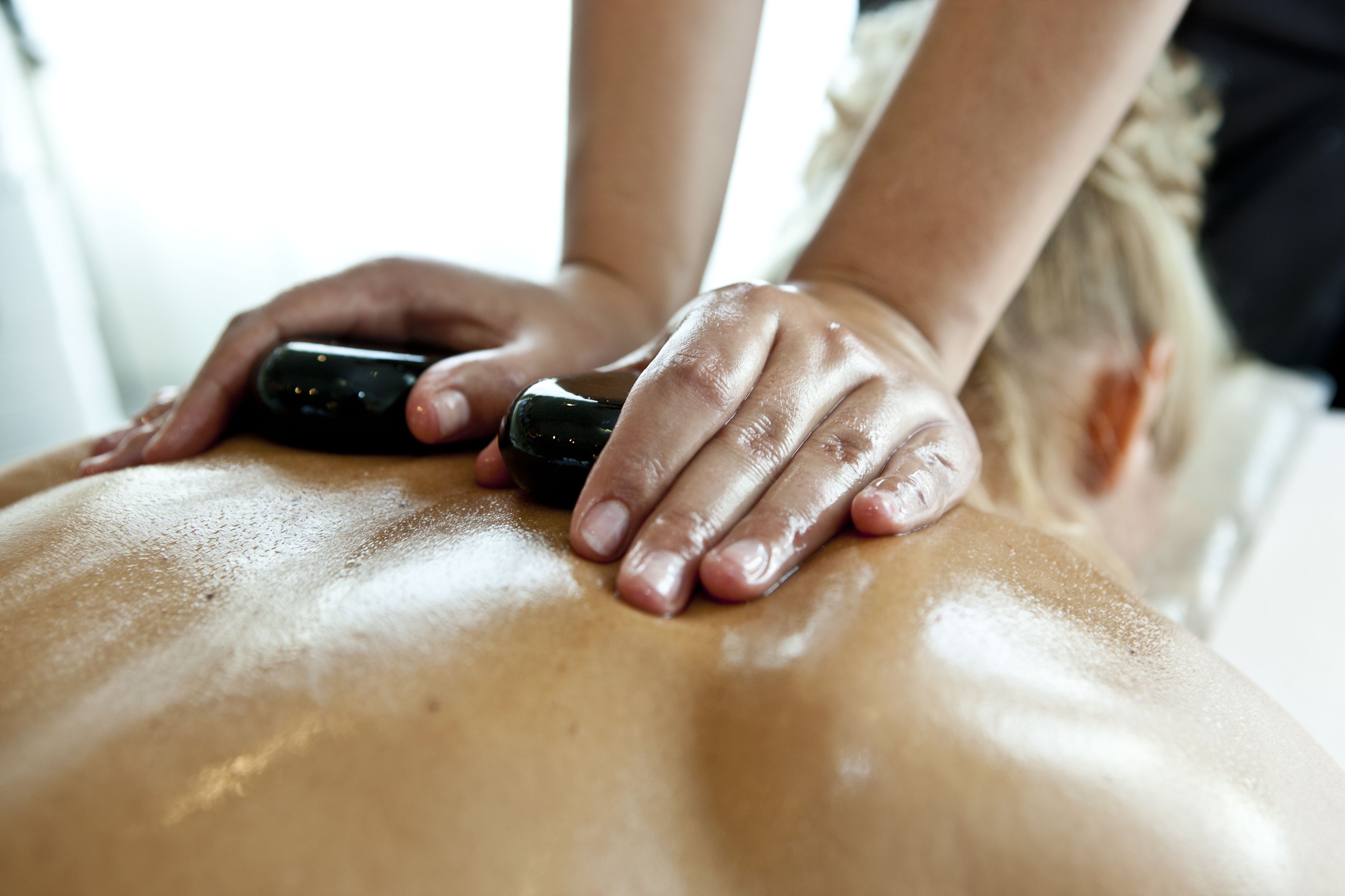 Une séance de massage axée sur les mains, qui exercent une pression sur le dos du client.