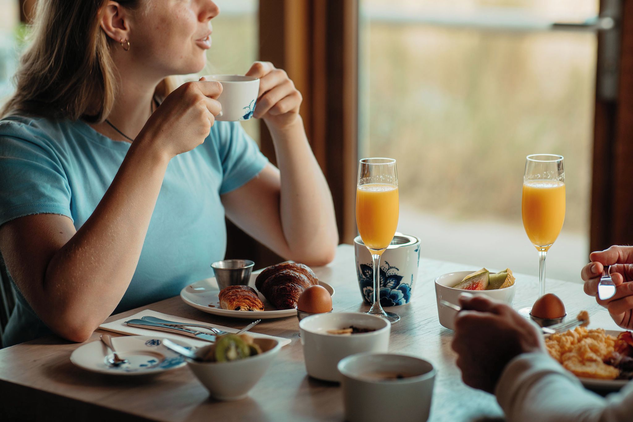 A breakfast setting with a table, plates, and glasses of orange juice.