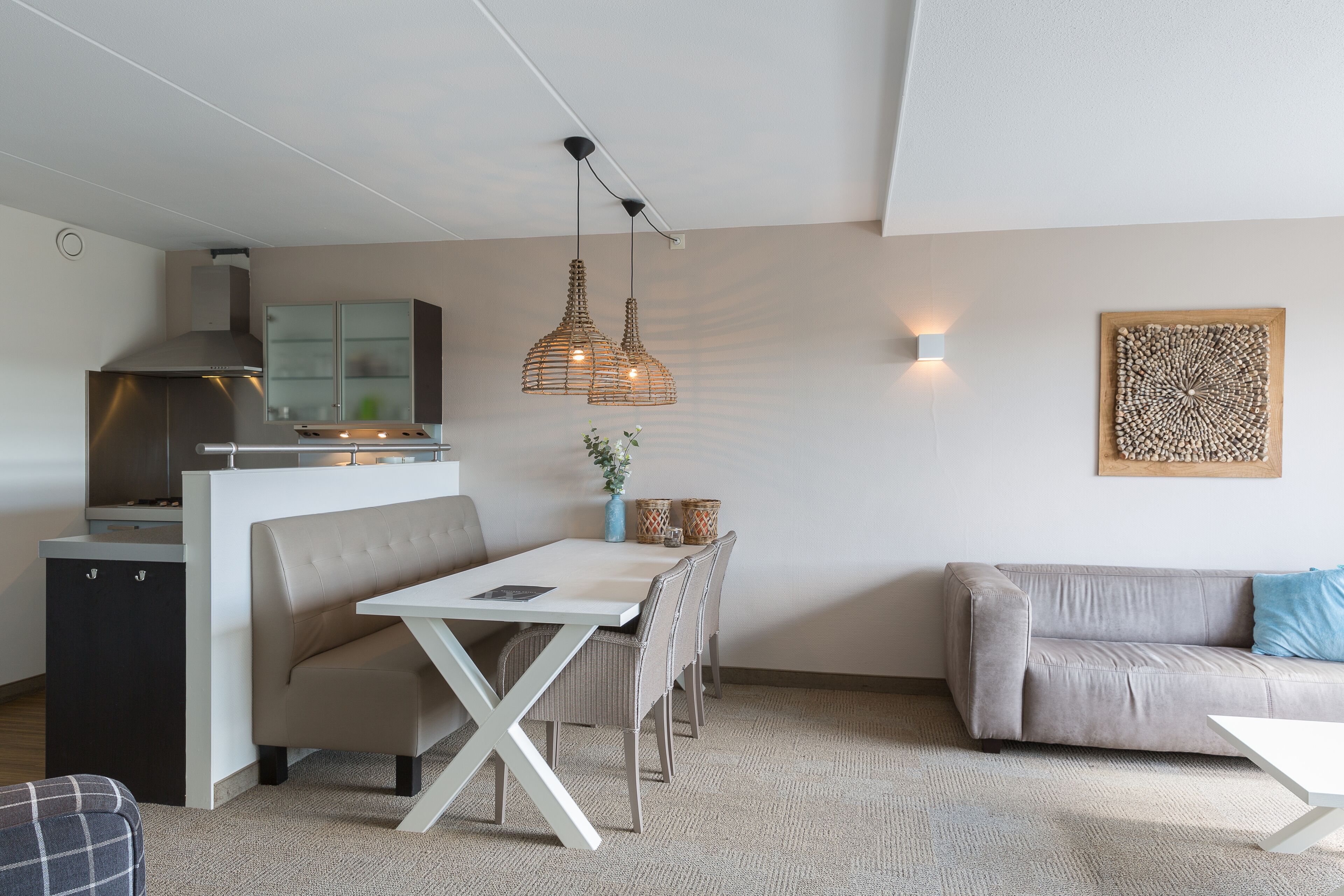Eine moderne Küche mit eingebautem Herd, einem Essbereich mit einer Bank und einem Sofa.