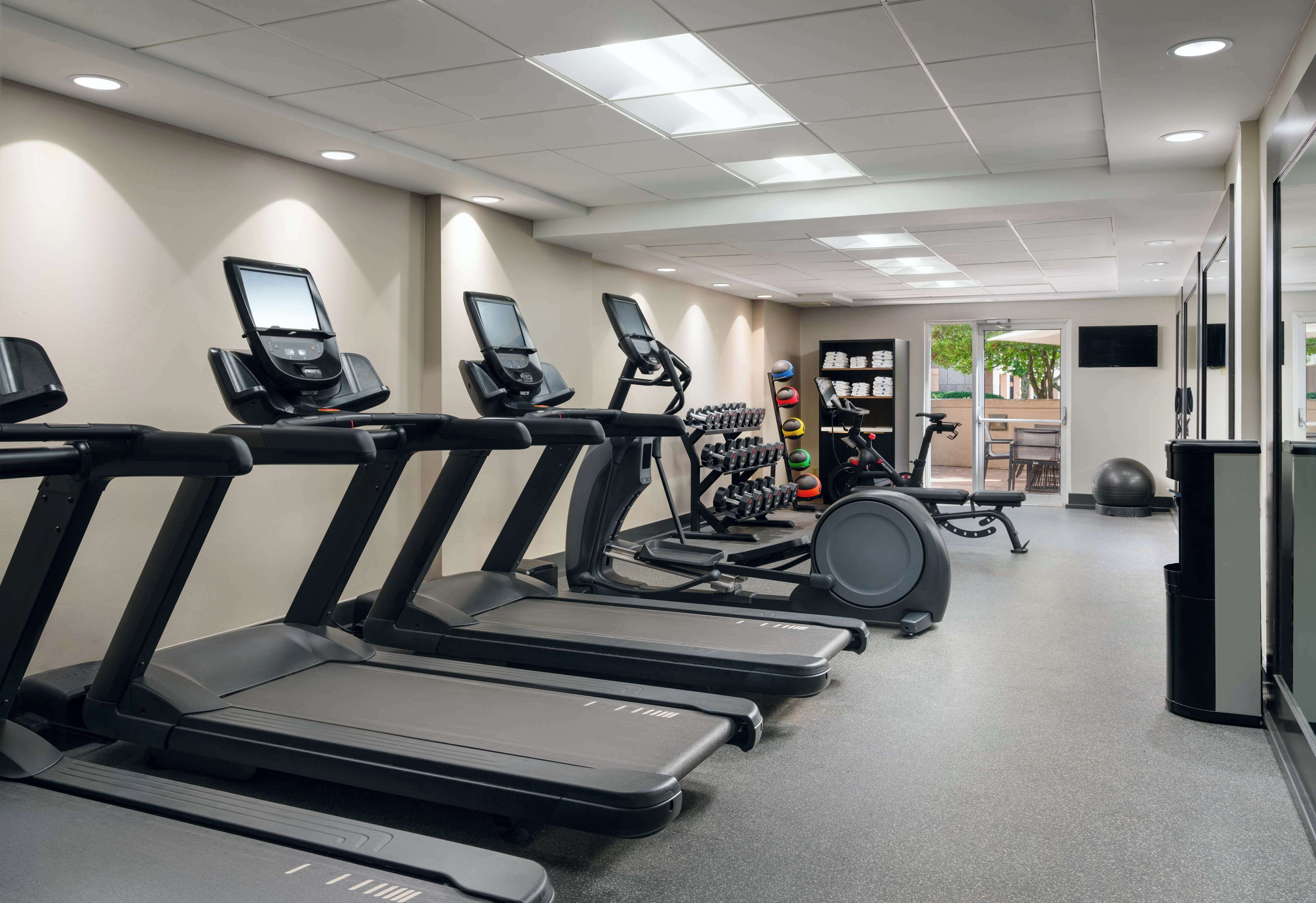 Ett gym med löpband, hantlar och träningsbollar.