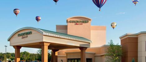 A Courtyard by Marriott hotel with a covered entrance and a parking lot.