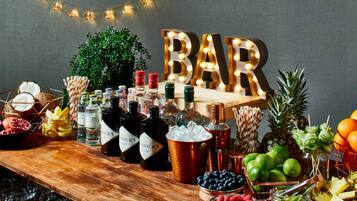 A bar setup with bottles, fruits, and a sign that reads "BAR".