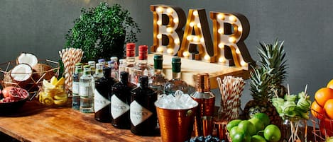 A bar setup with bottles, fruits, and a sign that reads "BAR".