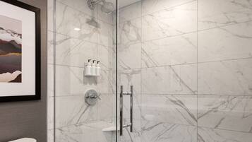 A modern bathroom with a glass-enclosed shower, a toilet, and marble tiles.