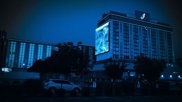 A hotel with a prominent illuminated sign and a large digital display on its facade.