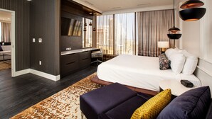 A modern hotel room with a large bed, a desk, and a view of the city. - J Resort (Reno)