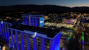 A high-rise hotel with illuminated blue lines and a large billboard advertising 'OverGlow'.
