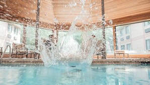 A pool with water splashing, surrounded by wooden walls and large windows. - Ann Arbor Regent Hotel & Suites (Ann Arbor)