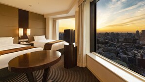 A hotel room with two beds, a TV, a desk, and a large window with a city view. - Shinagawa Prince Hotel (Tokyo)