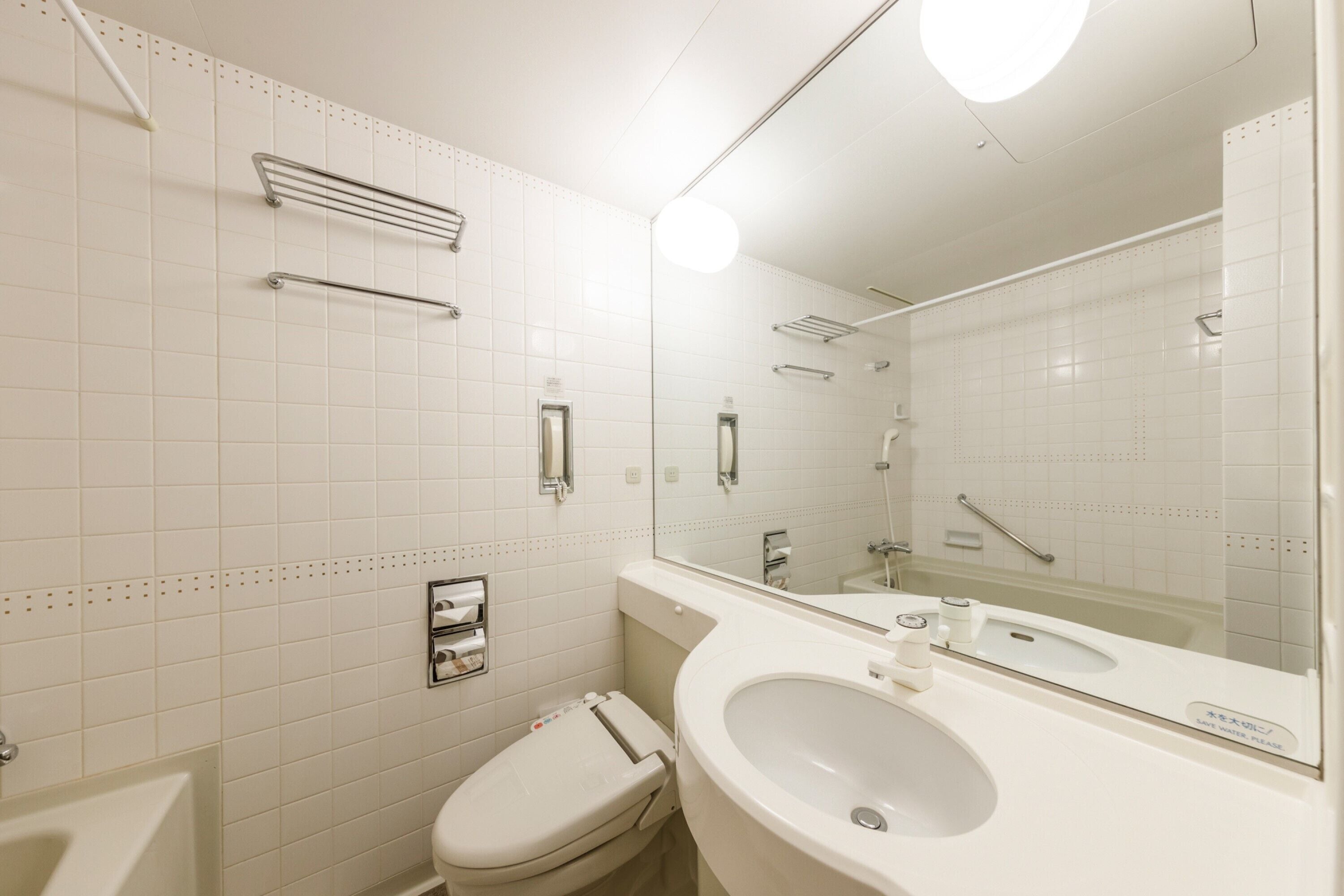 A modern bathroom with a white sink, toilet, and shower.