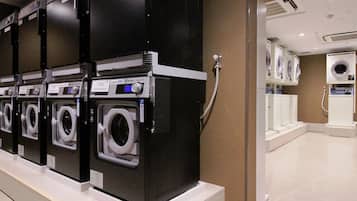 A row of black and white washing machines in a commercial setting.
