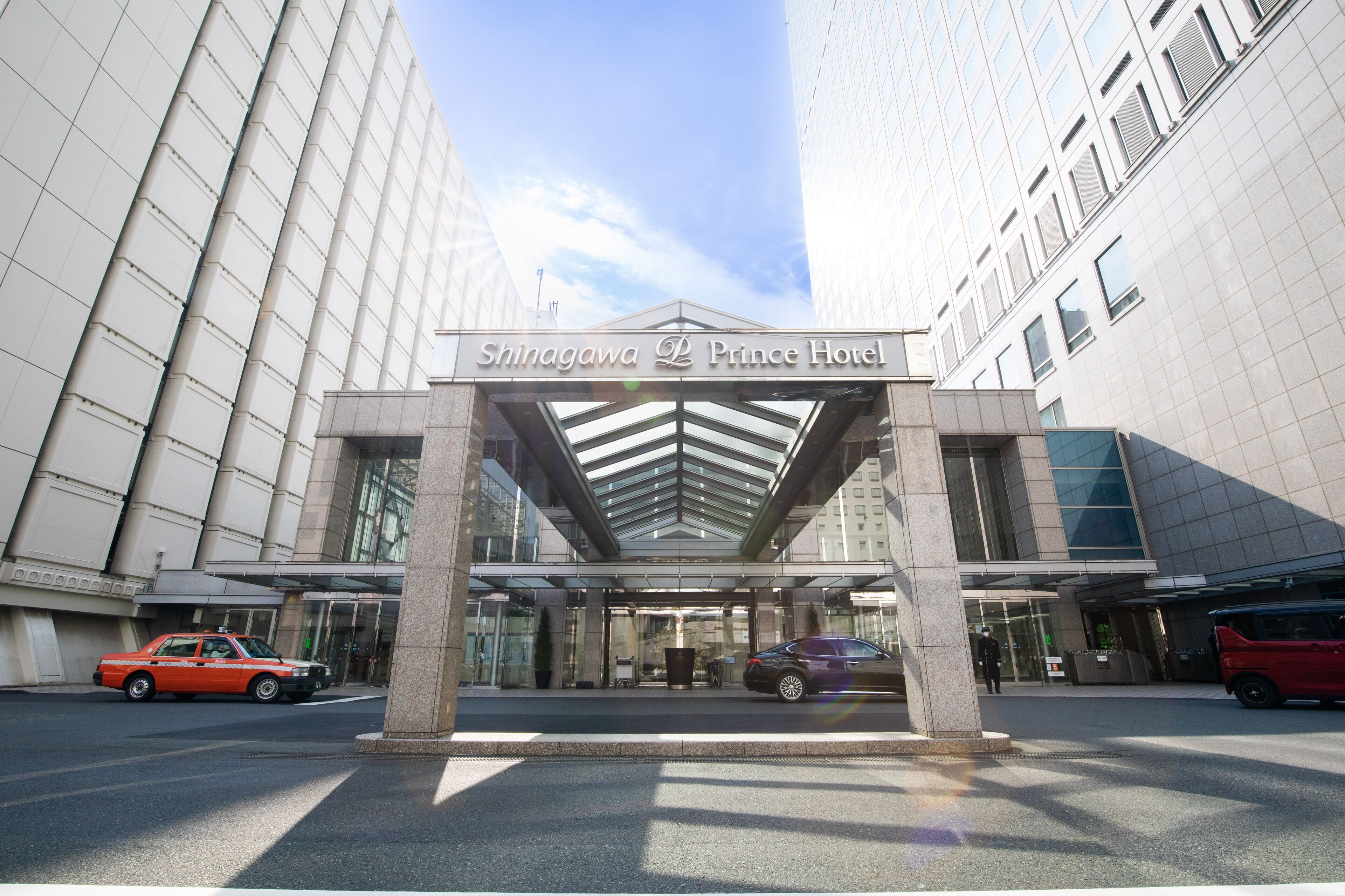 The entrance of Shinagawa Prince Hotel with a modern glass facade and a covered entrance area.