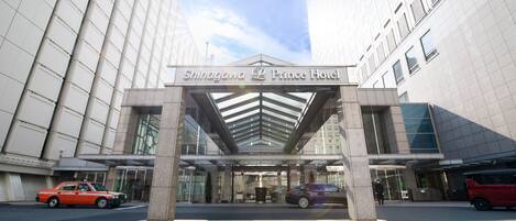 The entrance of Shinagawa Prince Hotel with a modern glass facade and a covered entrance area.