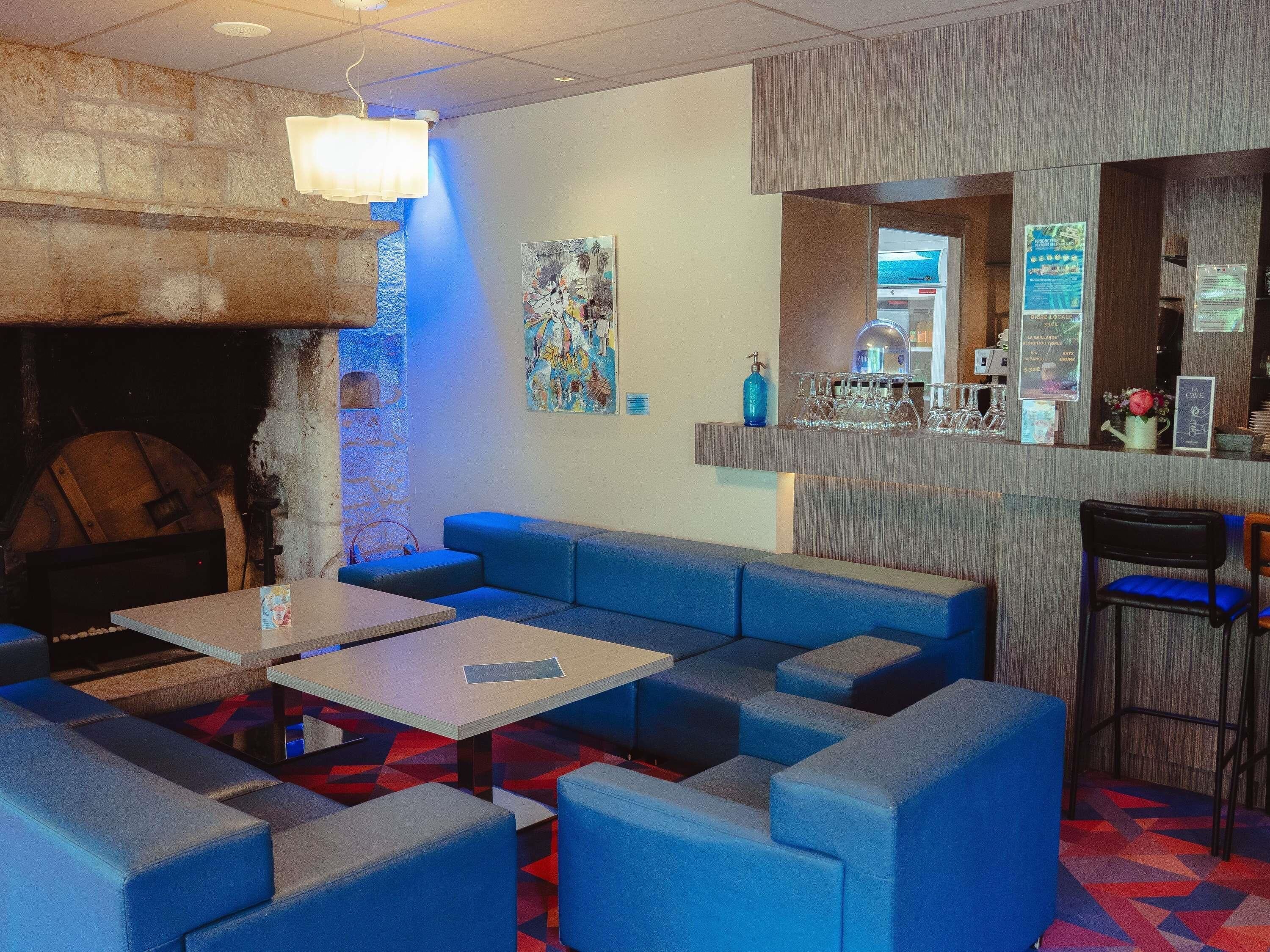 Een bar met zitplaatsen, een toog en een muurschildering.