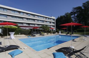 Piscine extérieure en saison, parasols, chaises longues