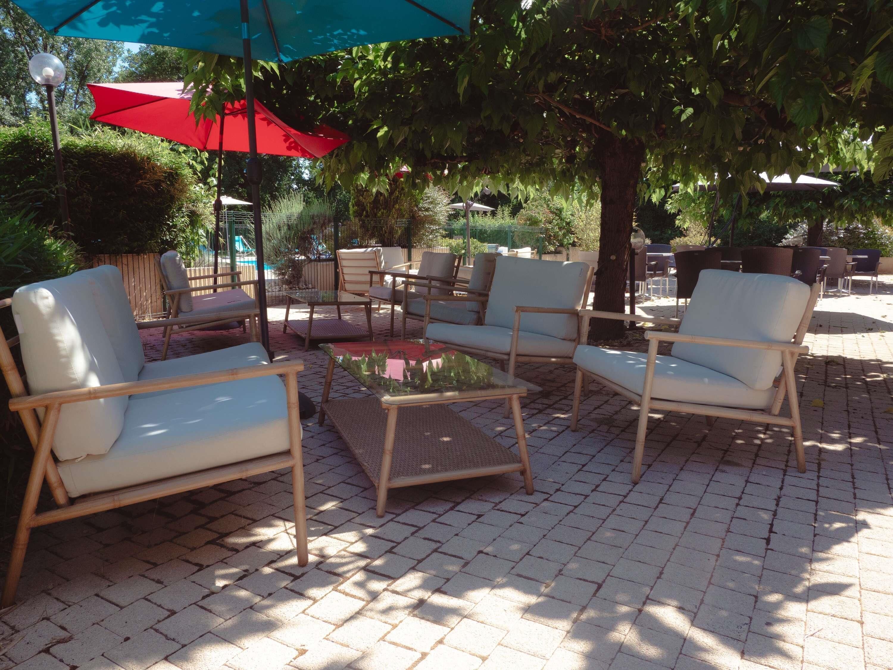 An outdoor seating area with wicker furniture and umbrellas.