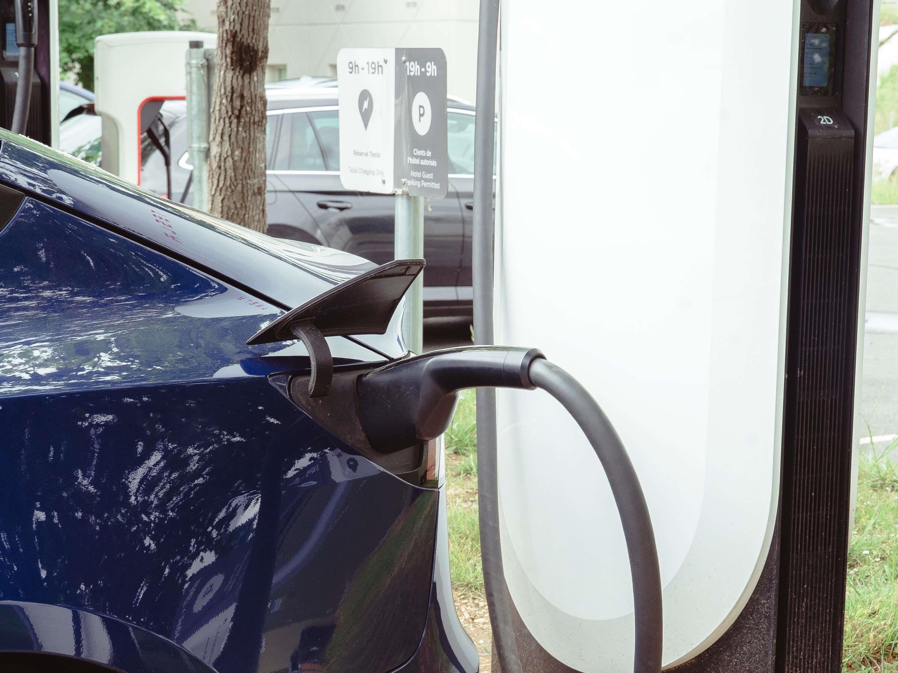 Una estación de carga de Tesla con un cable de carga conectado a un vehículo Tesla.