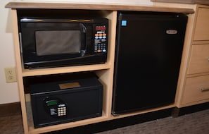 A compact kitchen with a microwave on the upper shelf and a refrigerator below. - Red Roof Inn Toledo - University (Toledo)