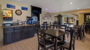 A hotel dining area with a counter, seating, and a television. - Best Western Cottage Grove Inn (Cottage Grove)