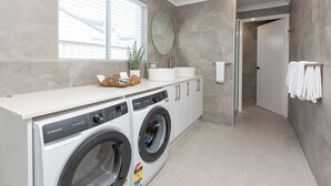Un lavadero moderno con lavadora, secadora y lavabo.