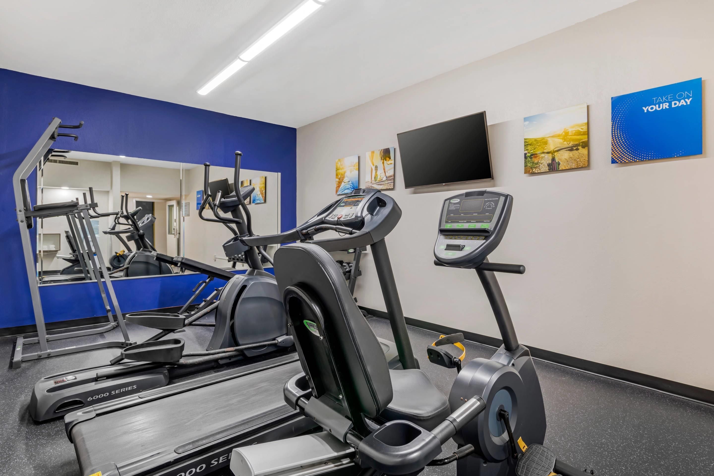 A gym with treadmills, a stationary bike, and a mirror.