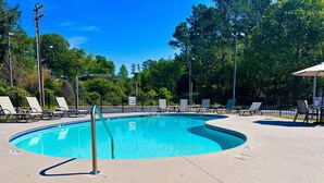 A swimming pool with lounge chairs and a no diving sign.