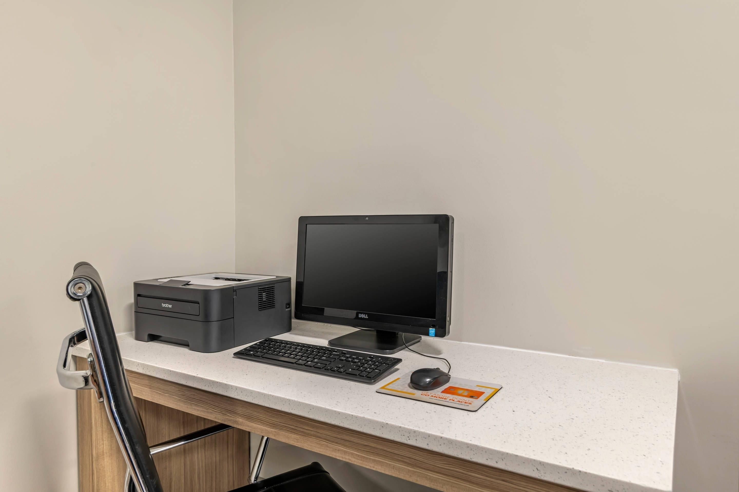 A desk with a computer, keyboard, mouse, and printer.