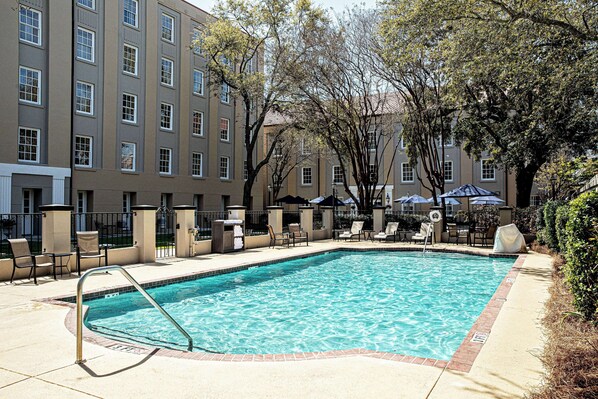Una piscina al aire libre, sombrillas, tumbonas